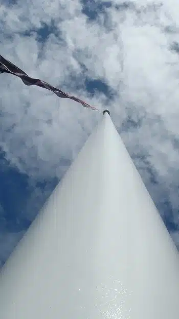 Looking straight up the 45-metre Auckland Airport flagpole toward the New Zealand flag and sky