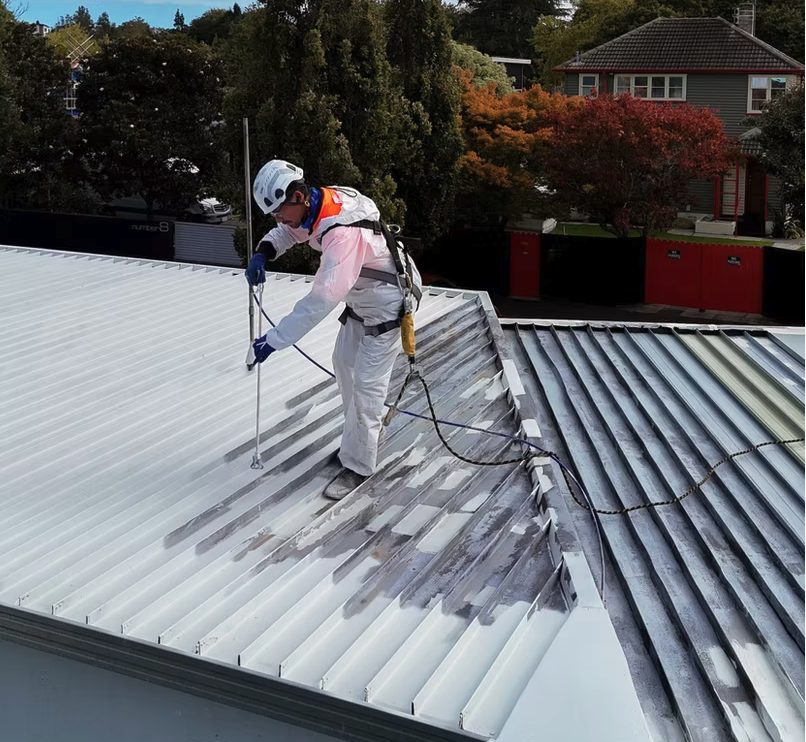Close-up of an applicator coating the standing seam roof pans with white Noxyde