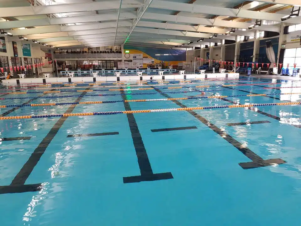 Indoor commercial lap pool with lane ropes finished in Rust-Oleum 9100 immersion epoxy