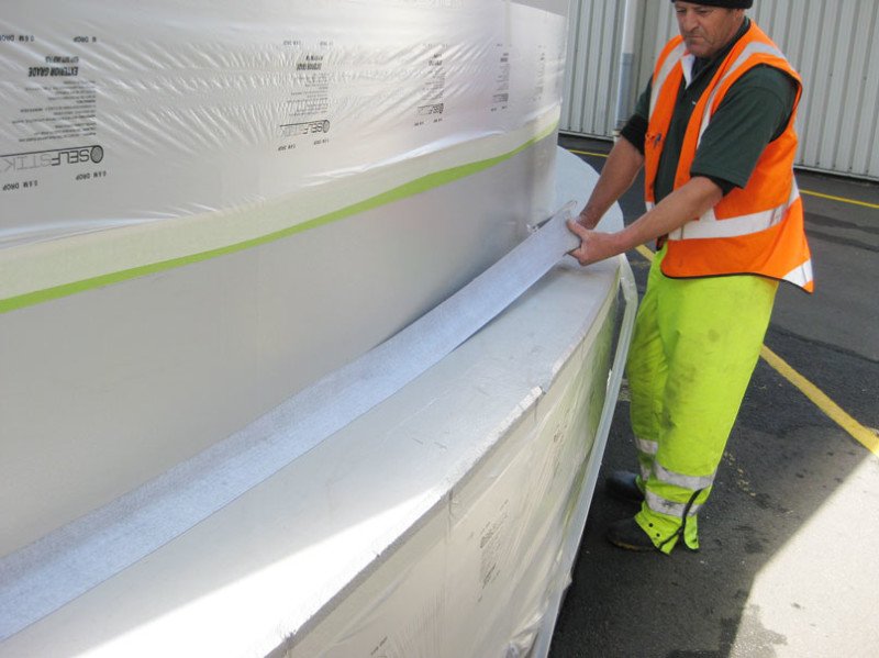 Applicator installing MMP Panel Bond Bandage across the silo to plinth joint