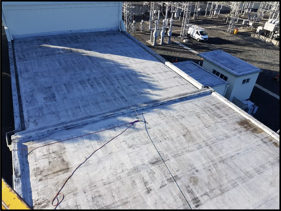 Transpower substation roof before coating, with a weathered and stained flat membrane